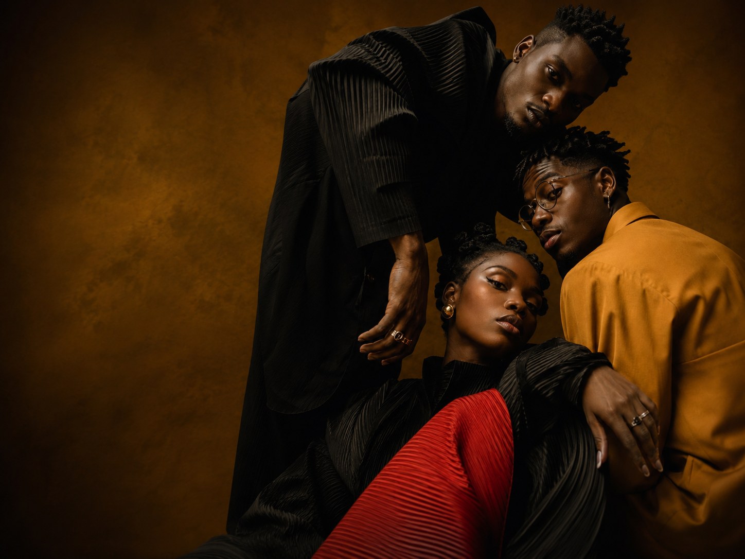 Three Black fashion models in a richly art-directed black, red and gold portrait